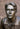 A bronze-finished bust sculpture of a young Joseph Smith with detailed hair, eyes, and clothing, in Angela Johnson's work This Is My Beloved Son, shown in a close-up portrait view against a blurred brown background.