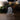 A clear acrylic or glass display block with an engraved portrait of Jesus Christ, based on the sculpture Come Unto Me by Angela Johnson, standing on a small clear base on a wooden surface with a softly blurred indoor background.