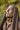 A bronze-toned statue of Jesus Christ with closed eyes, a beard, and a draped robe, in Angela Johnson's work O My Father, photographed outdoors against a blurred green background.