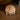 A bronze-toned medallion featuring an embossed kneeling Jesus Christ and the engraved text 'Neither do I condemn you,' displayed on a small clear stand on a wooden surface.