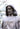 A realistic statue of Jesus Christ with long hair, a beard, and a V-neck tunic, based on Angela Johnson's work Here Is My Beloved Son, shown in a close-up outdoor shot with a blurred natural background.