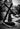 Black and white photograph of a stone Jesus carrying cross sculpture in a garden setting, in Angela Johnson's work Because of Love.