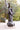 Statue of Jesus Christ carrying a cross in Angela Johnson's work Because of Love, a natural setting with trees.